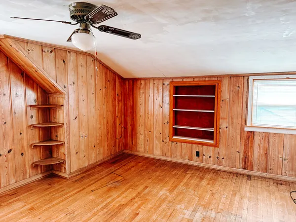 a view of an entryway with wooden floor and cabinet