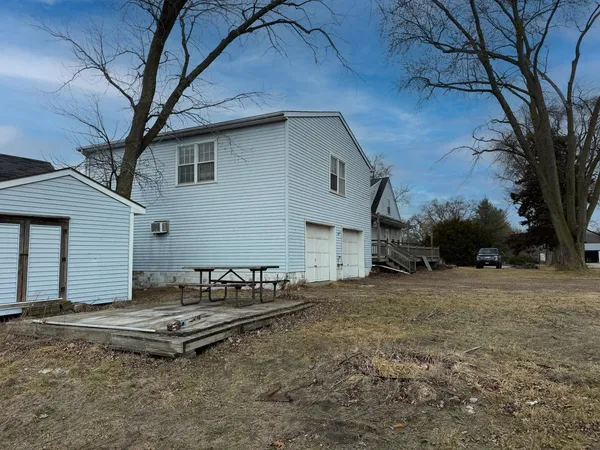 a backyard of a house with table and chairs