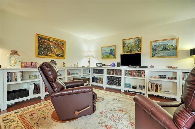 4625 Fifth Avenue, Unit 710 Pittsburgh, PA 15213 - Photo 5 of 12 a living room with furniture a flat screen tv and bookshelf