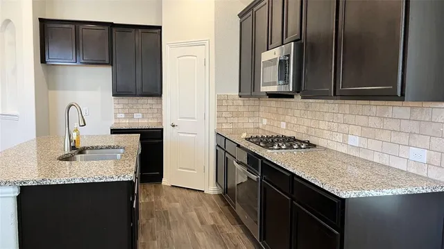 an empty room with wooden floor fireplace and windows
