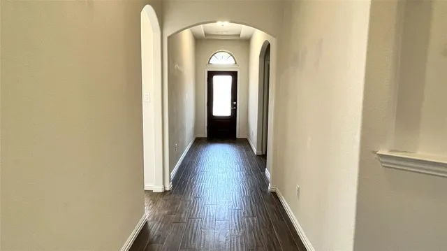 a view of a hallway with wooden floor and a entryway