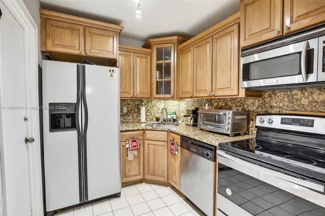 a kitchen with stainless steel appliances granite countertop a refrigerator and a stove top oven