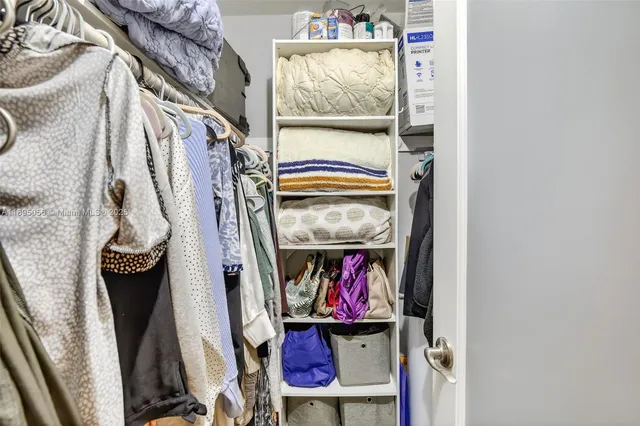 a view of walk in closet with clothes
