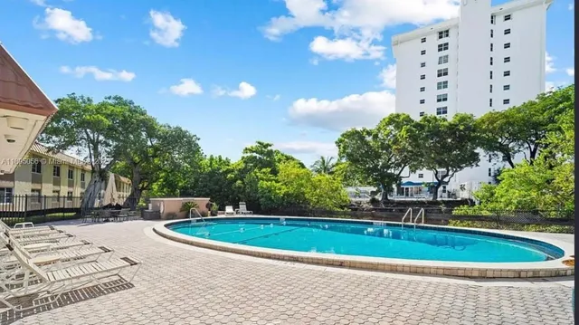 a view of a swimming pool with a yard and plants