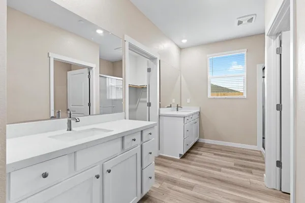 a bathroom with a double vanity sink a mirror and a bathtub