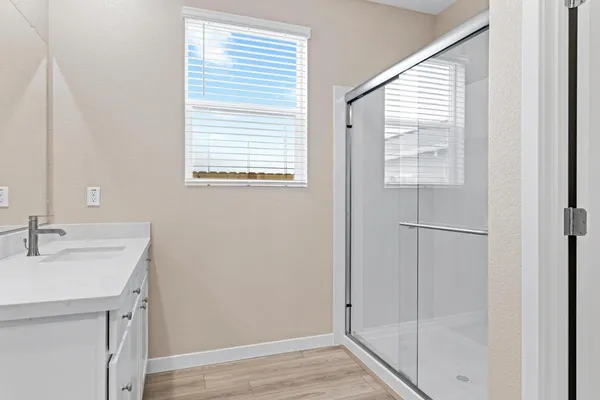 a bathroom with a sink a mirror and next to a window
