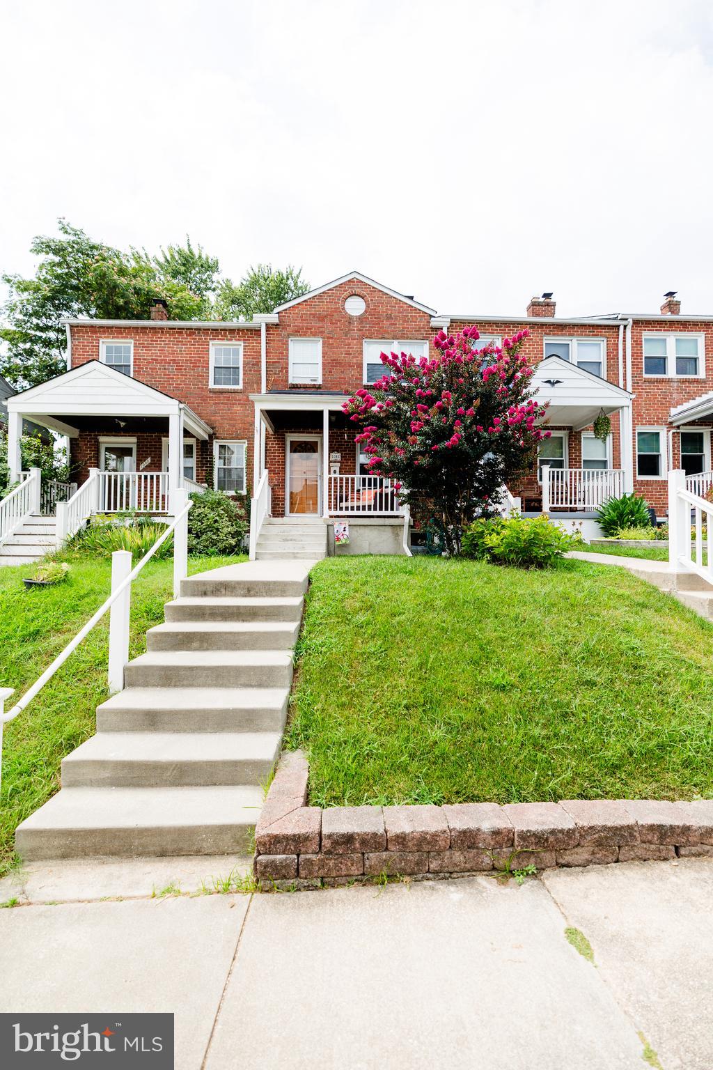 1083 Elm Road Baltimore, MD 21227 - Photo 1 of 33 a front view of a house with a garden and trees