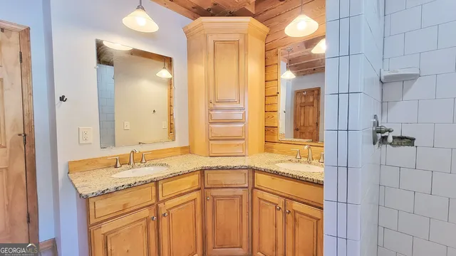 a bathroom with a shower sink and mirror