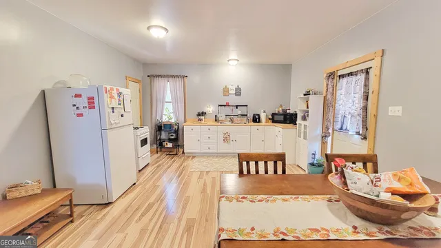 a living room with furniture a refrigerator and kitchen view