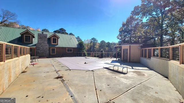 a view of a roof deck with chair and wooden fence