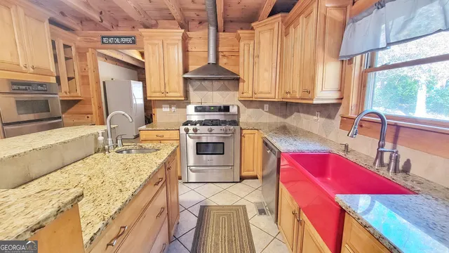 a kitchen with stainless steel appliances granite countertop a stove a sink and a microwave