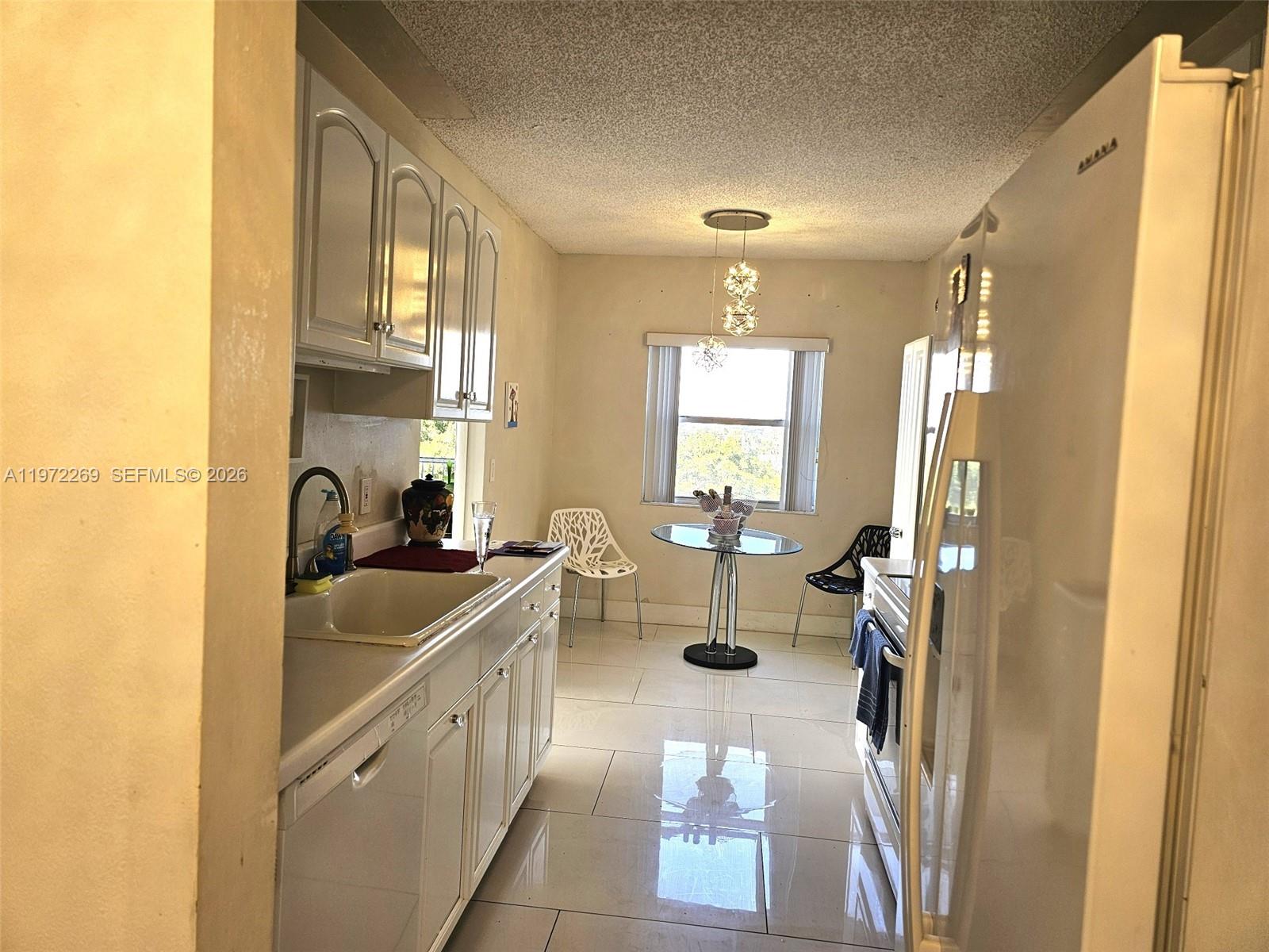 3850 Washington Street, Unit 516 Hollywood, FL 33021 - Photo 5 of 17 a kitchen with sink refrigerator and window