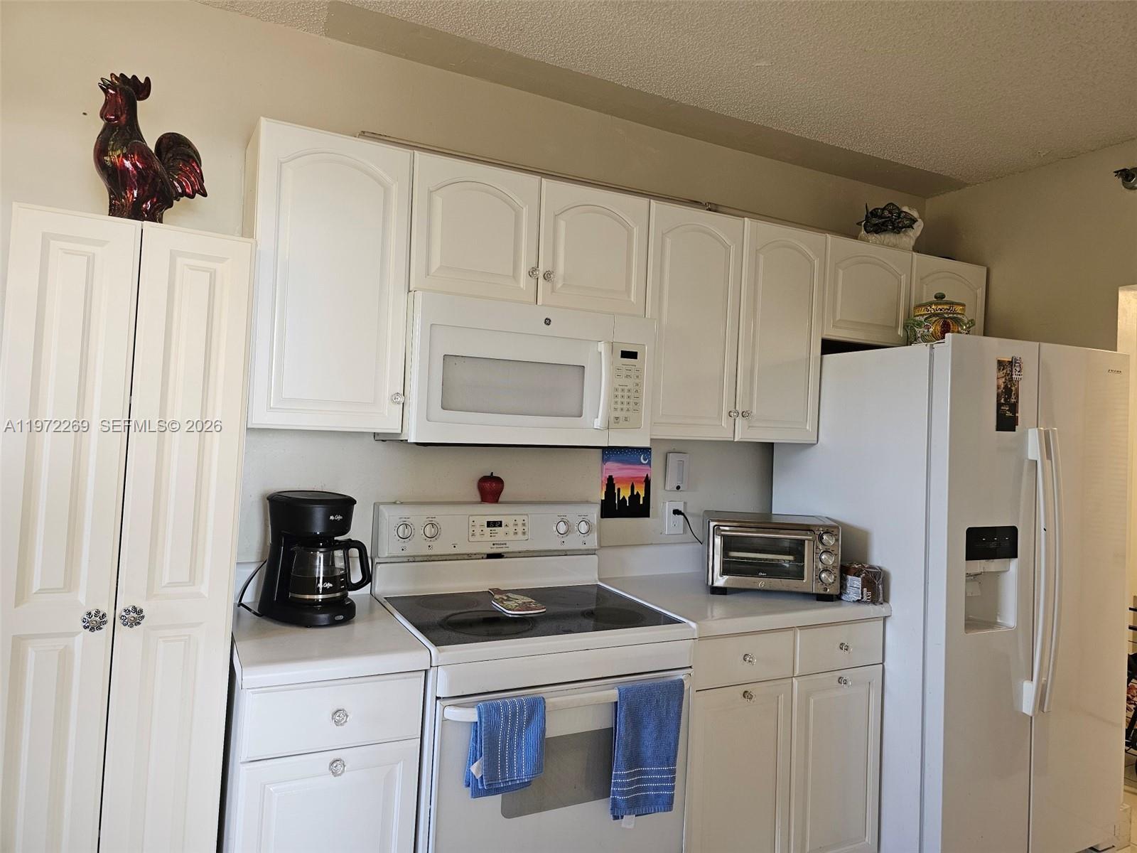 3850 Washington Street, Unit 516 Hollywood, FL 33021 - Photo 6 of 17 a kitchen with white cabinets and white appliances