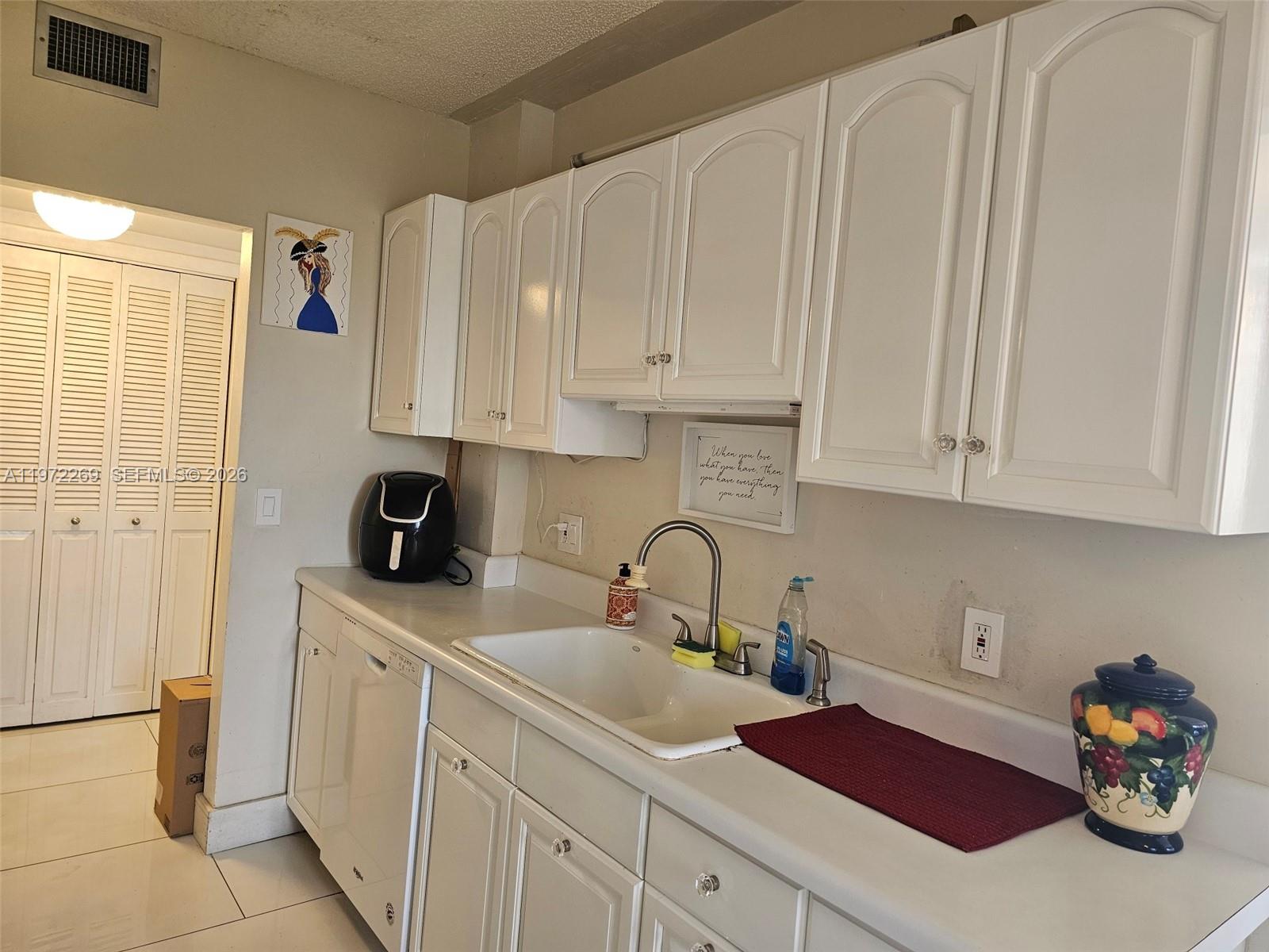 3850 Washington Street, Unit 516 Hollywood, FL 33021 - Photo 7 of 17 a kitchen with white cabinets and sink