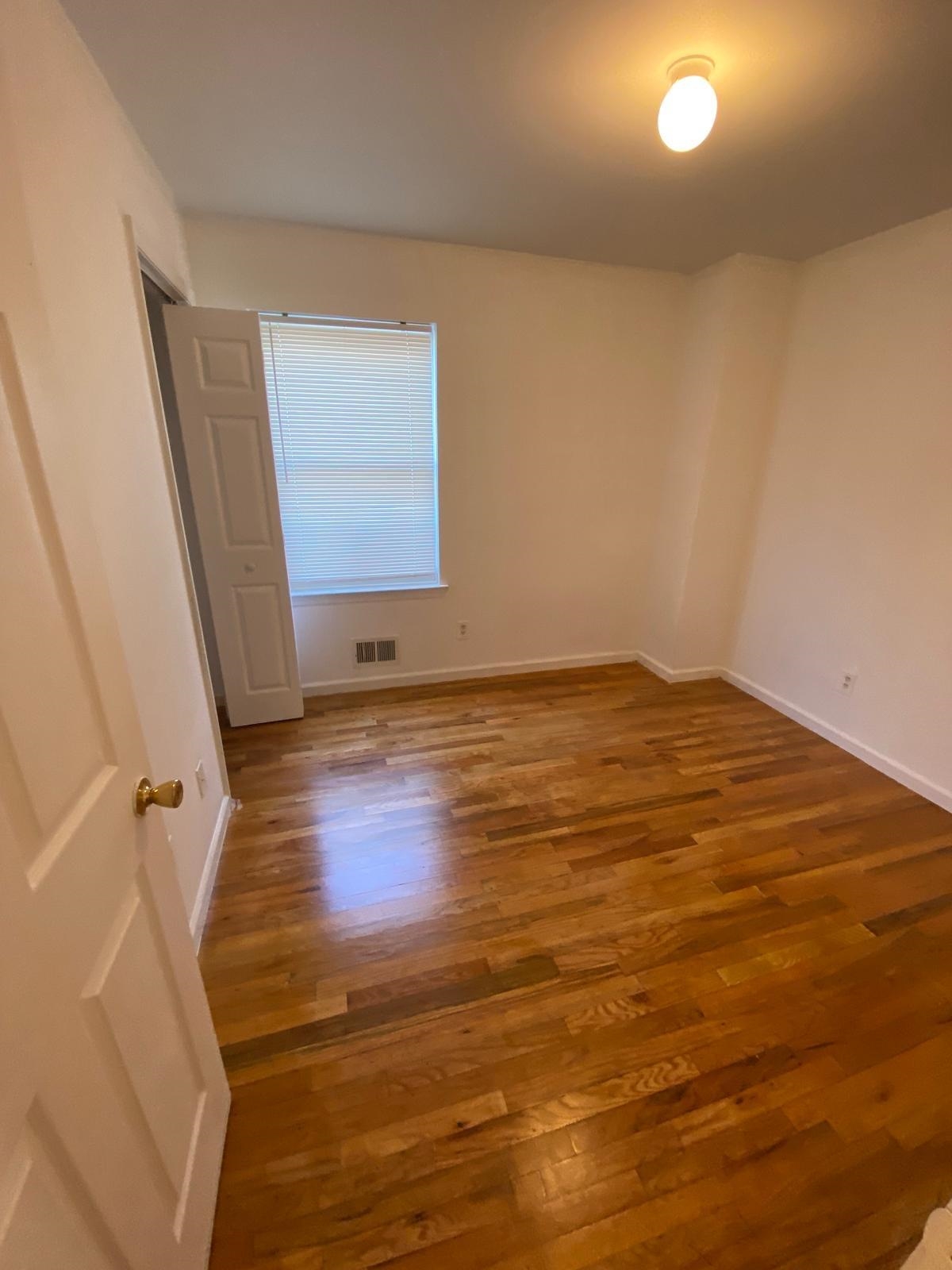 225 Belvidere Avenue, Unit 2 Jersey City, NJ 07306 - Photo 3 of 18 an empty room with wooden floor and windows