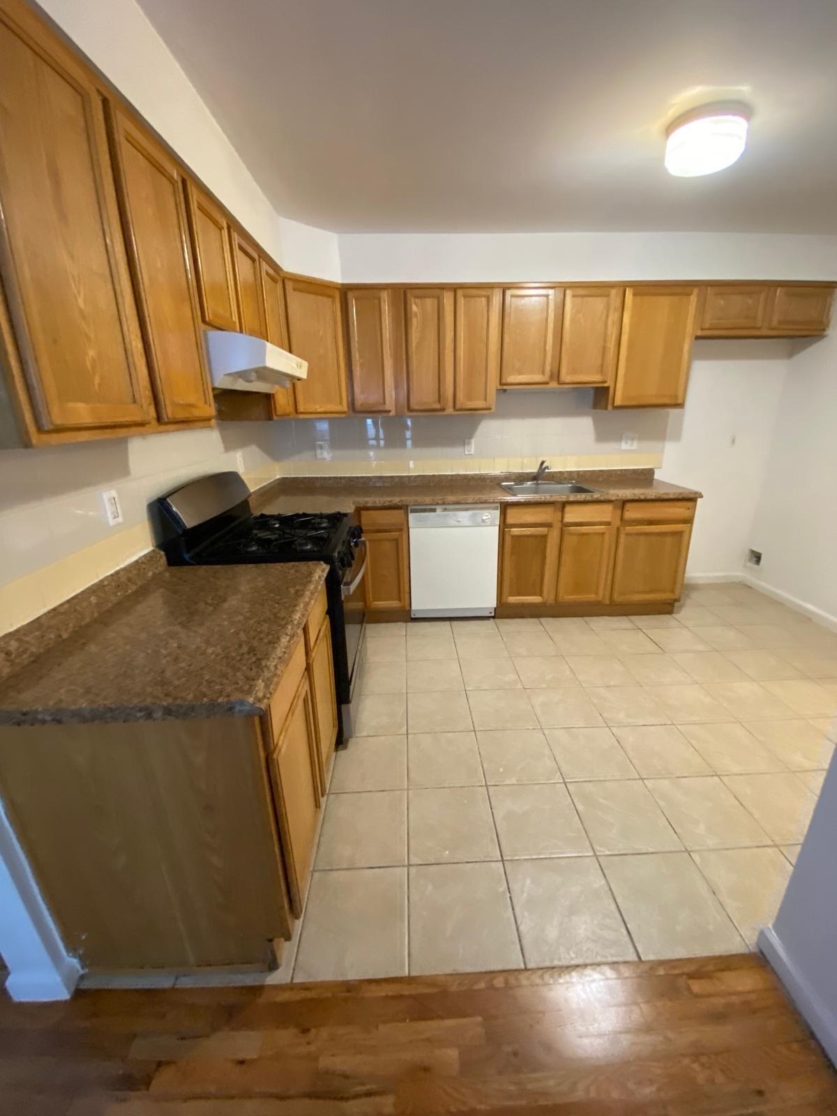 225 Belvidere Avenue, Unit 2 Jersey City, NJ 07306 - Photo 5 of 18 a kitchen with stainless steel appliances granite countertop a sink and a stove