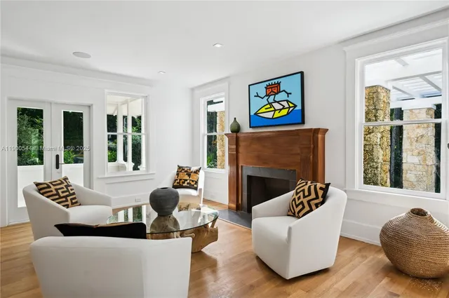 a living room with fireplace furniture and a large window