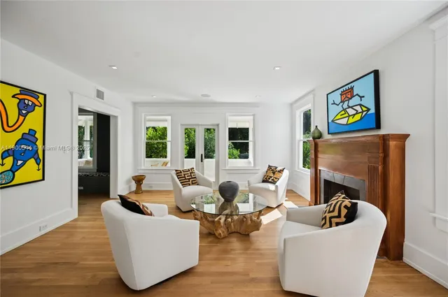 a living room with furniture a fireplace and a large window