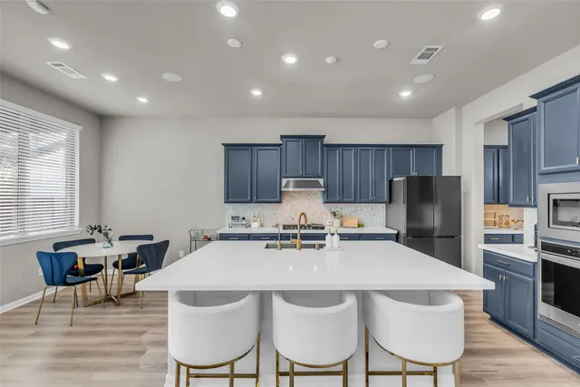 a kitchen with refrigerator and cabinets