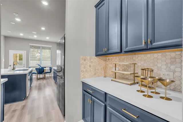 a large kitchen with stainless steel appliances a stove a sink dishwasher a dining table and chair with the wooden floor