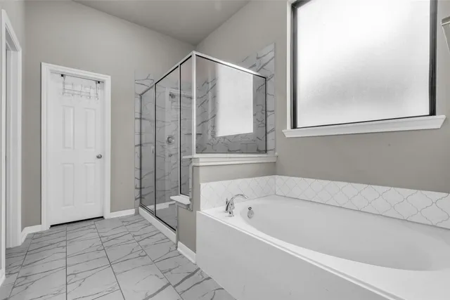 a en suite bathroom with a tub sink and mirror