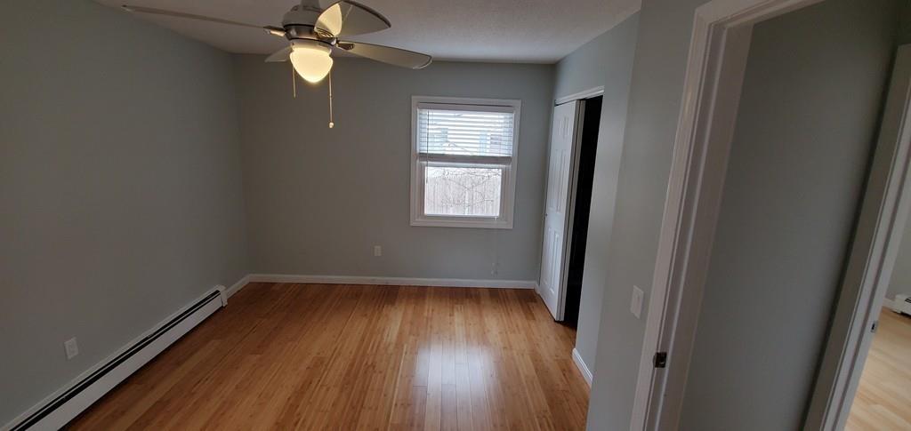 211 New Boston Road Sturbridge, MA 01566 - Photo 14 of 23 an empty room with wooden floor fan and windows