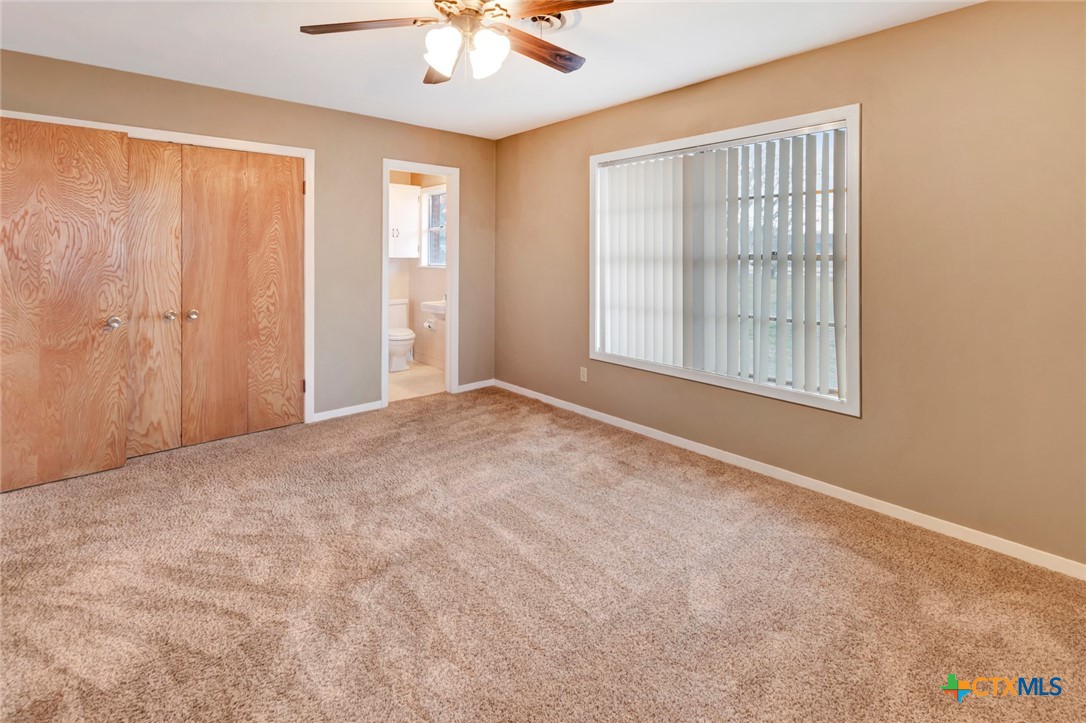 711 Northgate Road Victoria, TX 77904 - Photo 24 of 37 an empty room with windows and chandelier fan