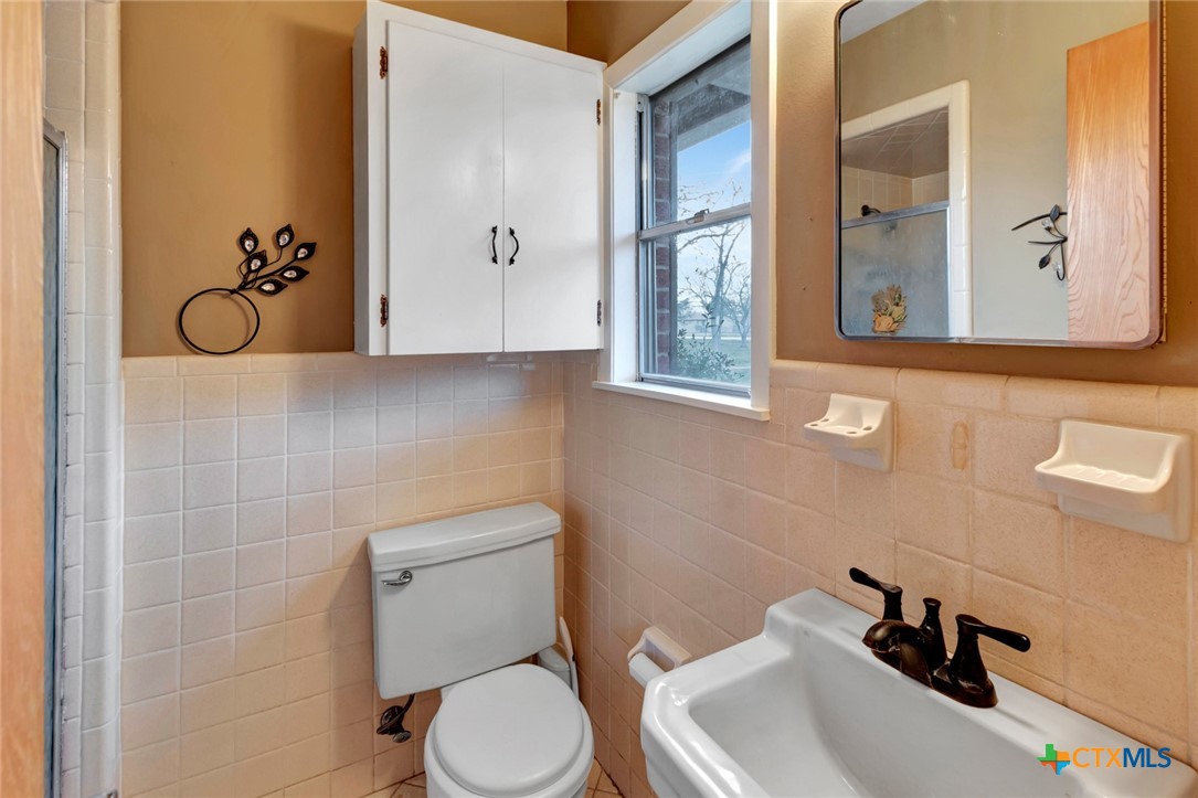 711 Northgate Road Victoria, TX 77904 - Photo 26 of 37 a bathroom with a toilet sink and mirror
