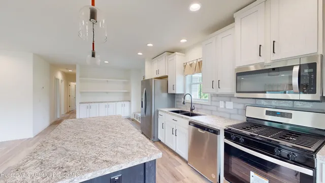 a kitchen with stainless steel appliances granite countertop a sink refrigerator and microwave