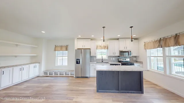 a kitchen with stainless steel appliances kitchen island granite countertop a stove and a sink