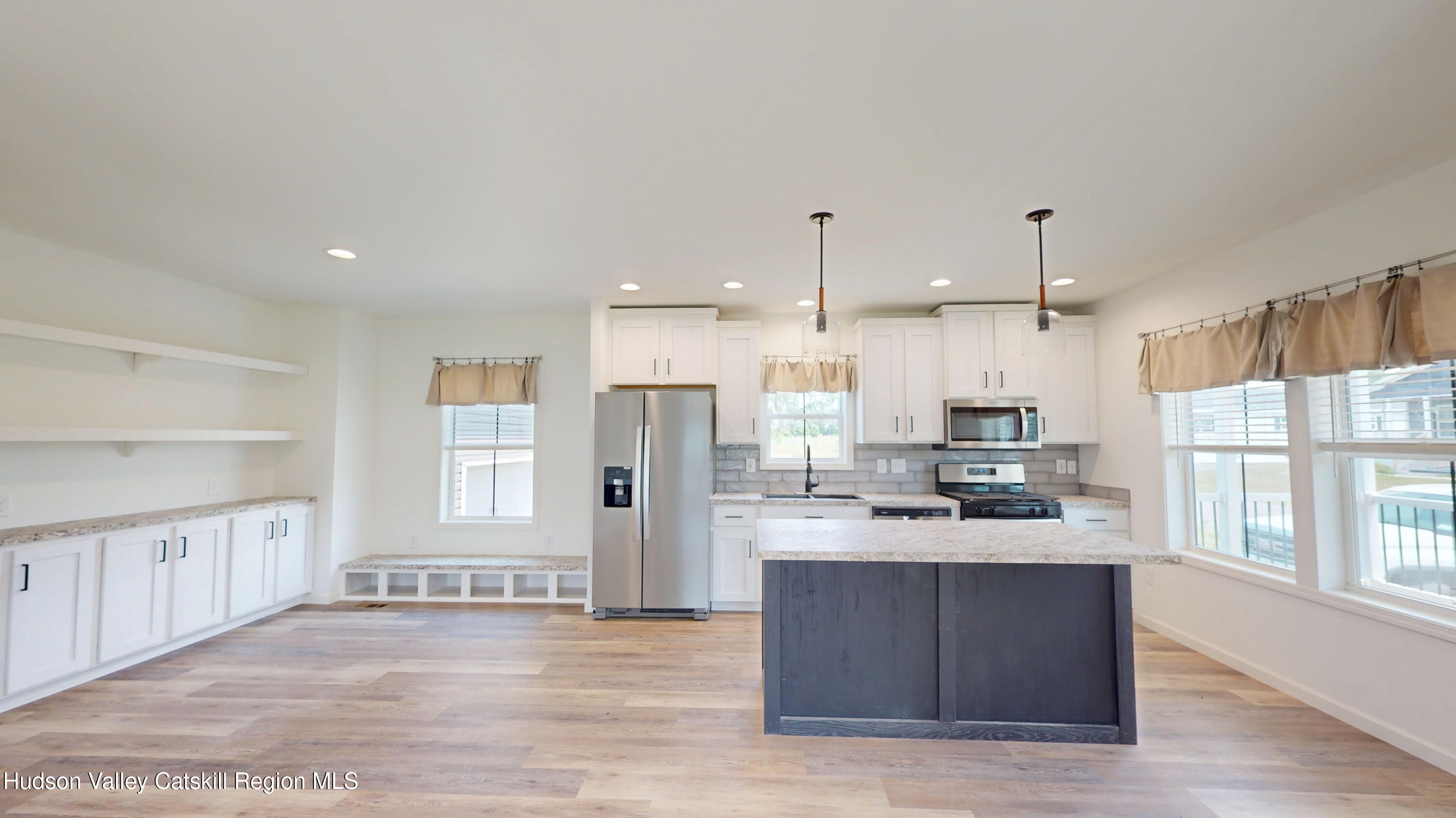 19 Mahoney Road Stuyvesant, NY 12173 - Photo 6 of 32 a large kitchen with stainless steel appliances kitchen island granite countertop a refrigerator a sink dishwasher and white cabinets with wooden floor