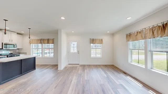 a view of empty room with wooden floor and window