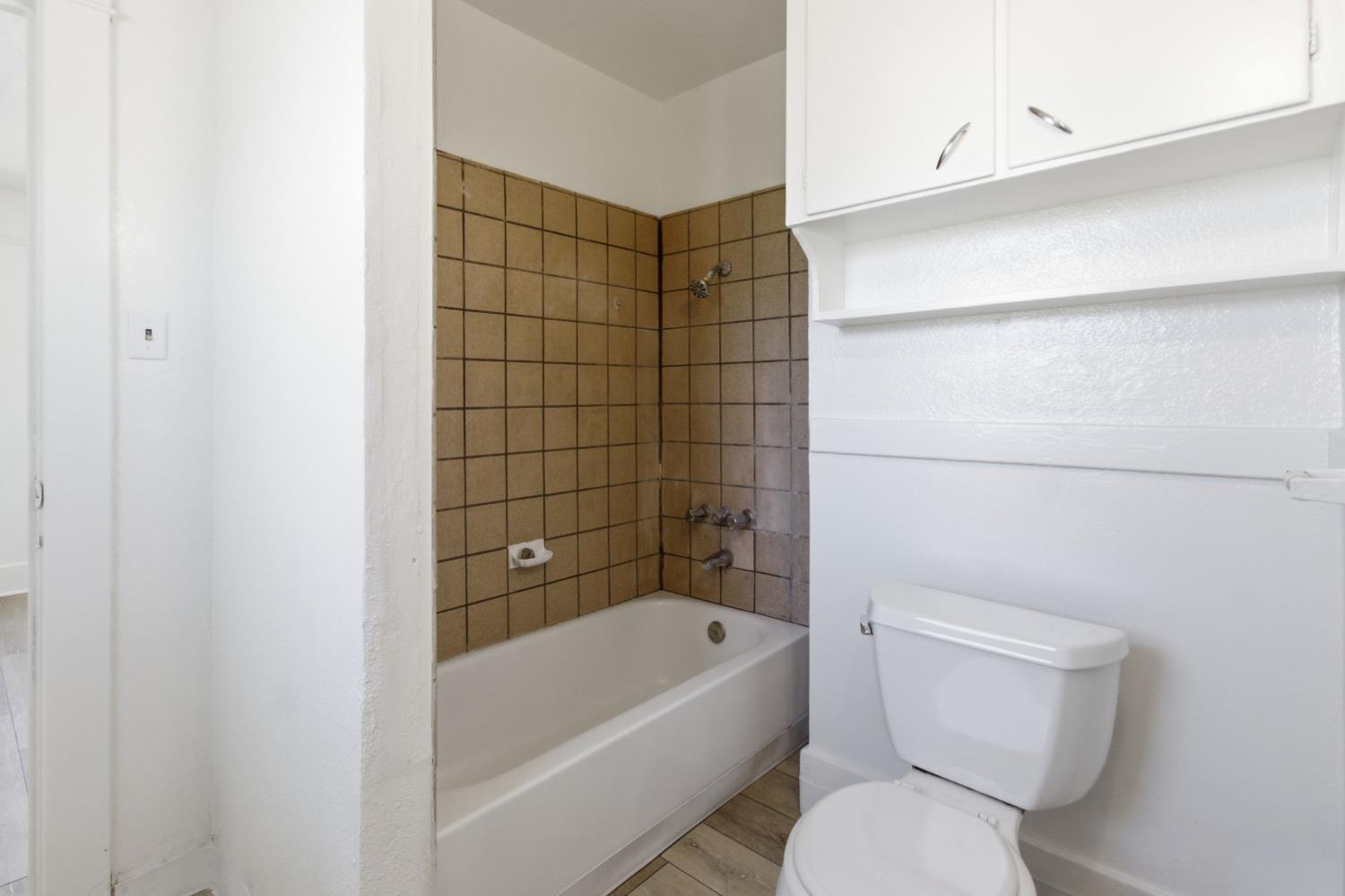 1014 3rd Street Los Banos, CA 93635 - Photo 13 of 21 a bathroom with a toilet and bathtub