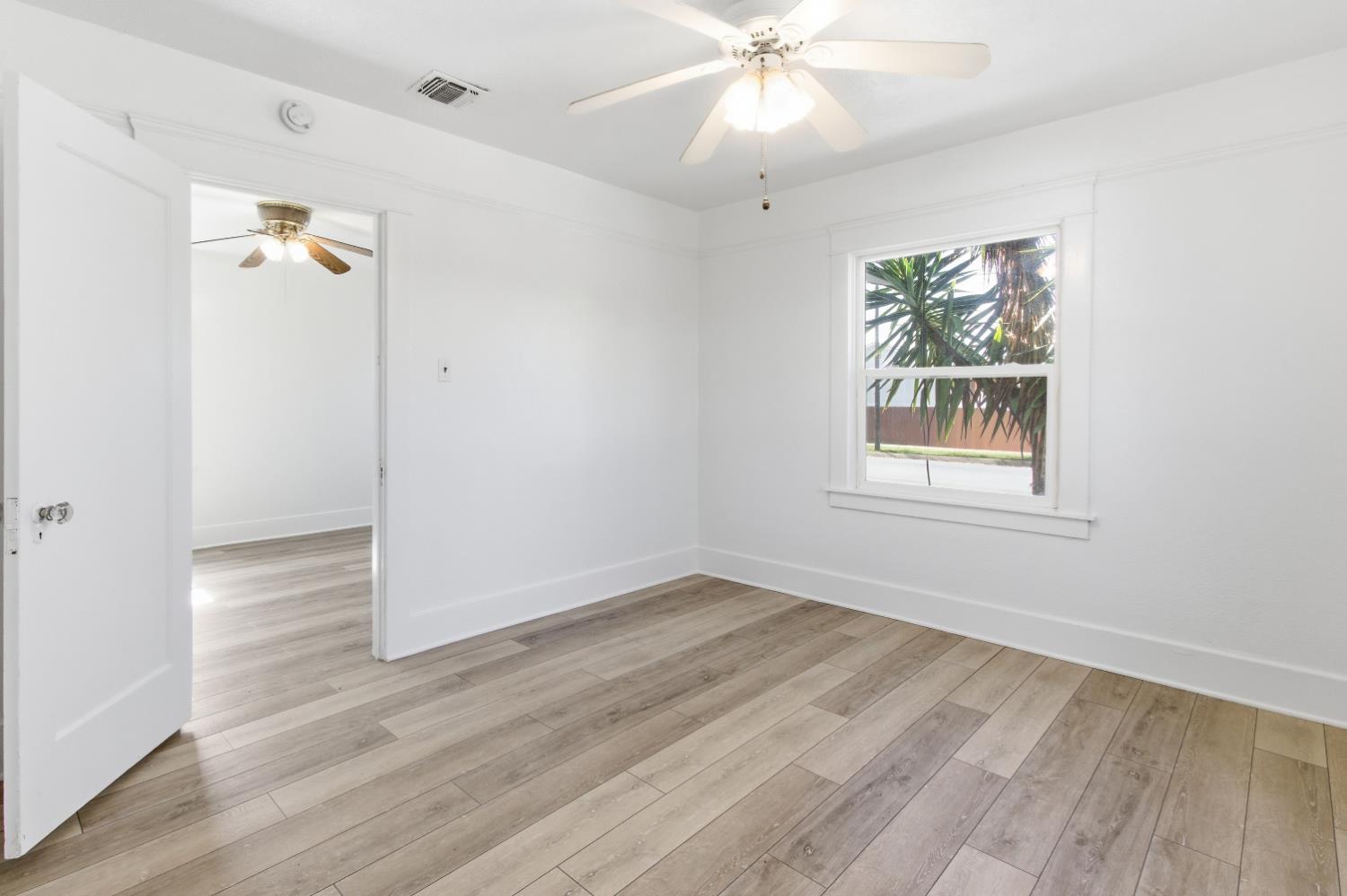 1014 3rd Street Los Banos, CA 93635 - Photo 15 of 21 wooden floor in an empty room with a window