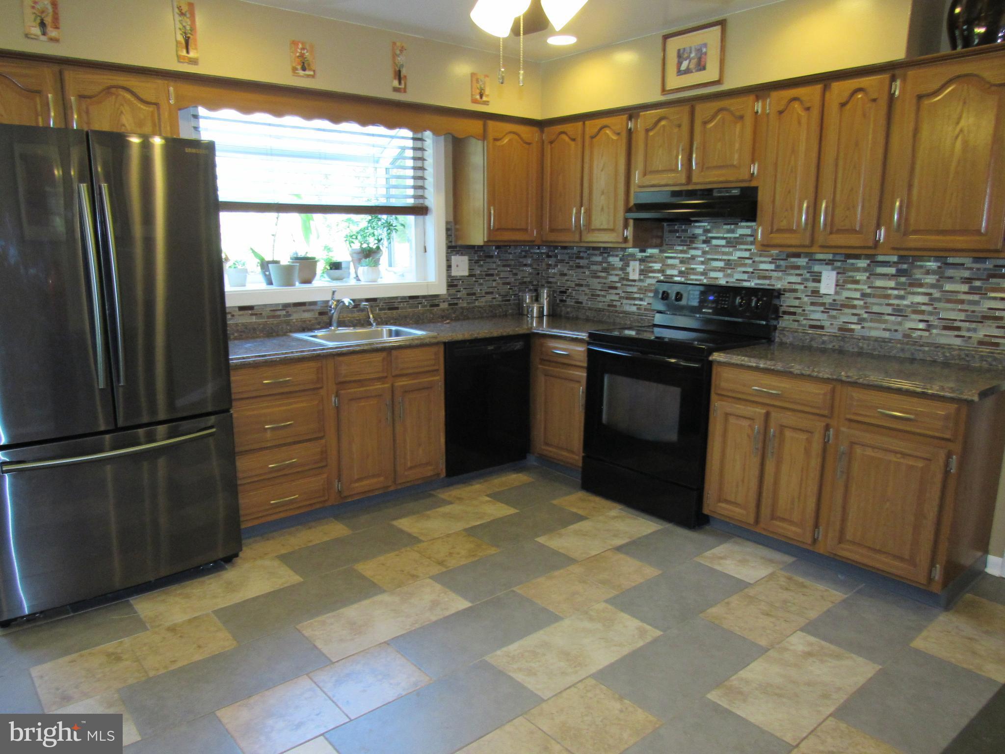 8710 Windsor Mill Road Baltimore, MD 21244 - Photo 11 of 30 a kitchen with stainless steel appliances granite countertop a refrigerator sink and cabinets