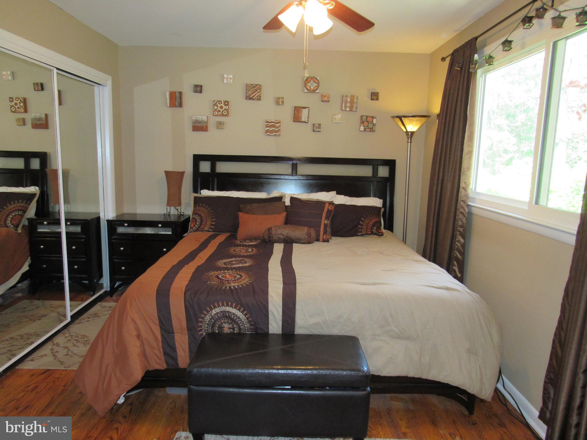 8710 Windsor Mill Road Baltimore, MD 21244 - Photo 13 of 30 a bedroom with a bed and wooden floor