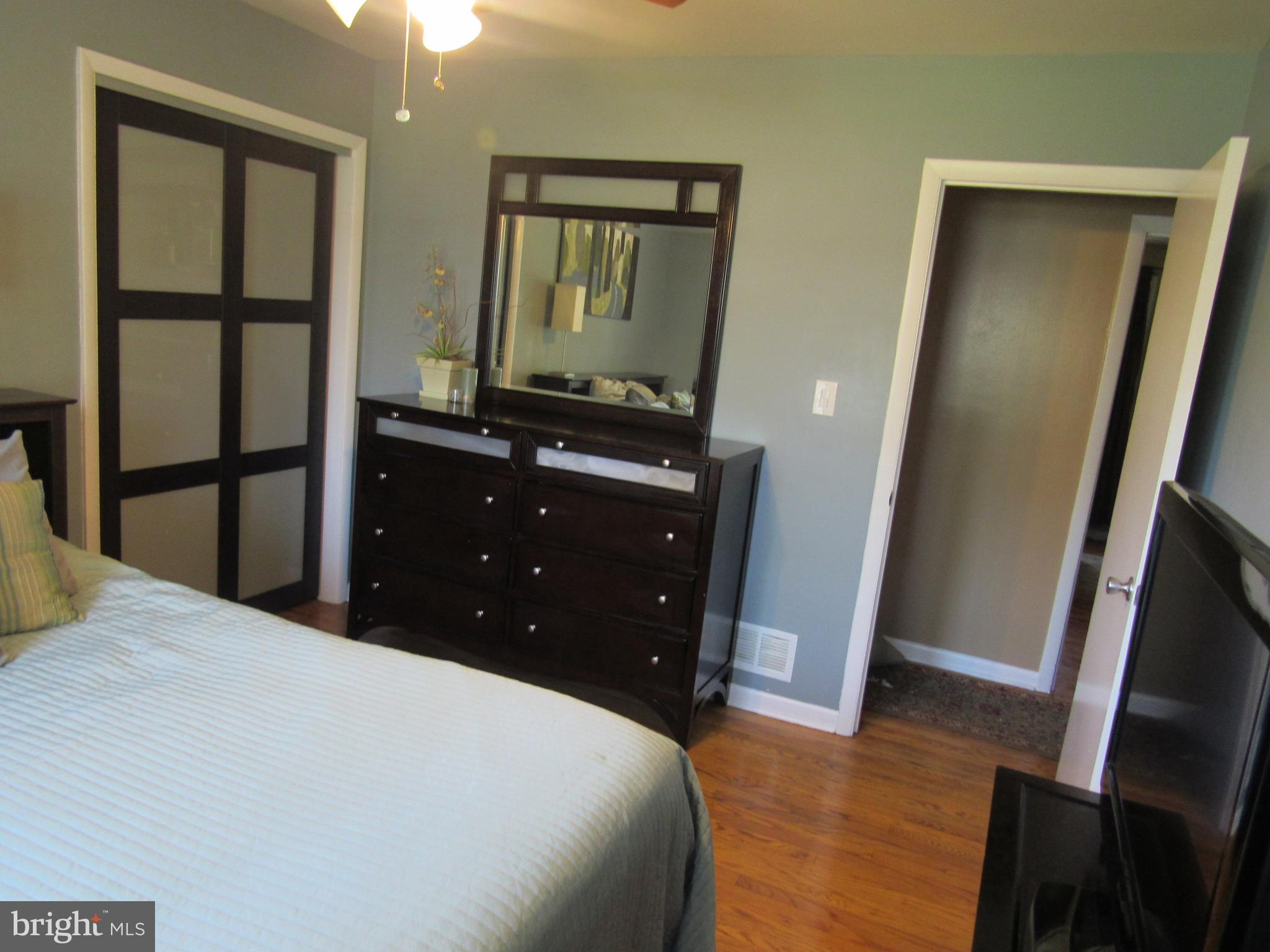 8710 Windsor Mill Road Baltimore, MD 21244 - Photo 17 of 30 a bedroom with a bed and a mirror on dresser