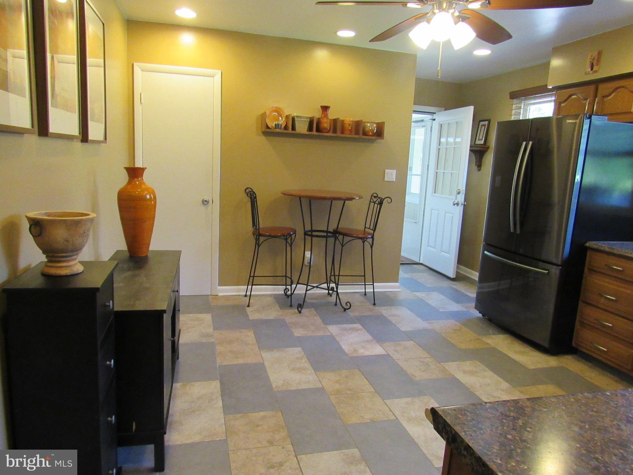 8710 Windsor Mill Road Baltimore, MD 21244 - Photo 9 of 30 a view of a refrigerator in kitchen and dining area with chandelier