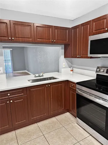 a kitchen with granite countertop a stove microwave and cabinets