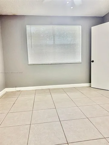 a view of a house with a yard and palm trees