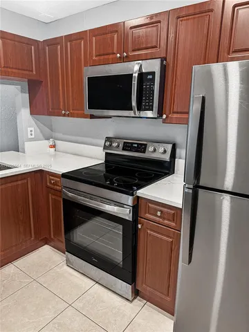 a kitchen with stainless steel appliances a stove a microwave and a refrigerator