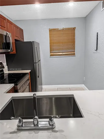 a view of kitchen with stainless steel appliances wooden floor and seating