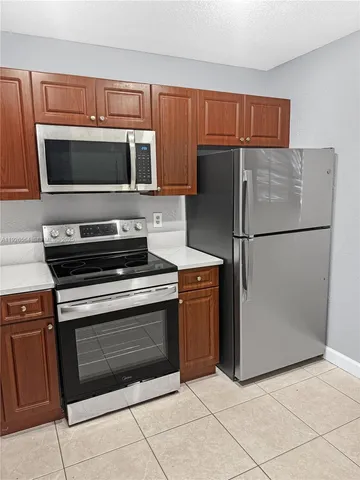 a kitchen with stainless steel appliances granite countertop a refrigerator stove and microwave