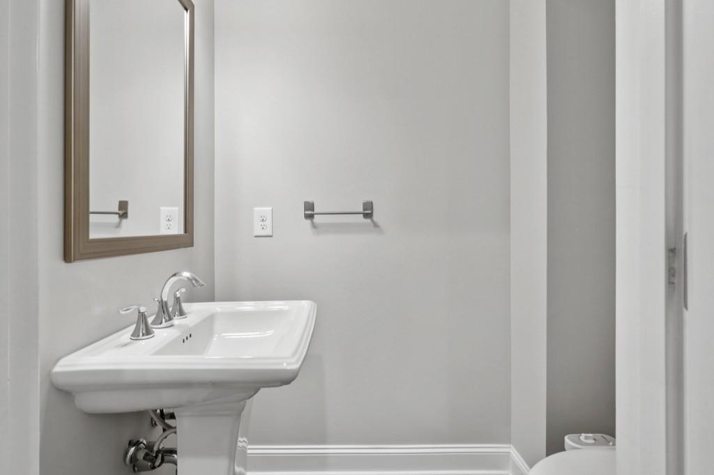 3899 Glenview Club Lane Duluth, GA 30097 - Photo 11 of 38 a bathroom with a sink a toilet and mirror