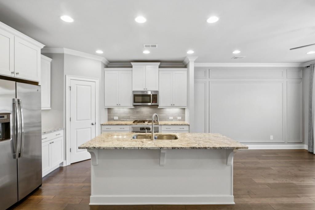 3899 Glenview Club Lane Duluth, GA 30097 - Photo 12 of 38 a kitchen with kitchen island stainless steel appliances a sink and refrigerator