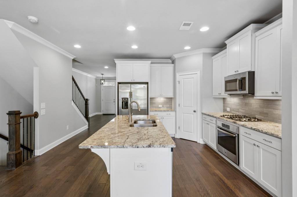 3899 Glenview Club Lane Duluth, GA 30097 - Photo 14 of 38 a kitchen with sink stove refrigerator and microwave