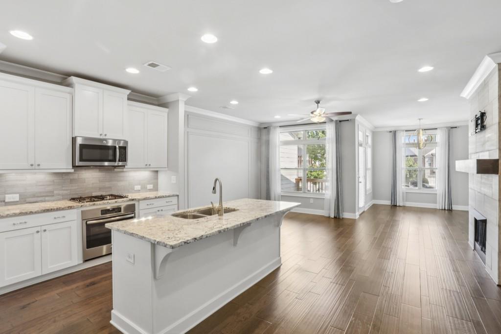 3899 Glenview Club Lane Duluth, GA 30097 - Photo 2 of 38 a large kitchen with stainless steel appliances granite countertop a lot of counter space and wooden floor