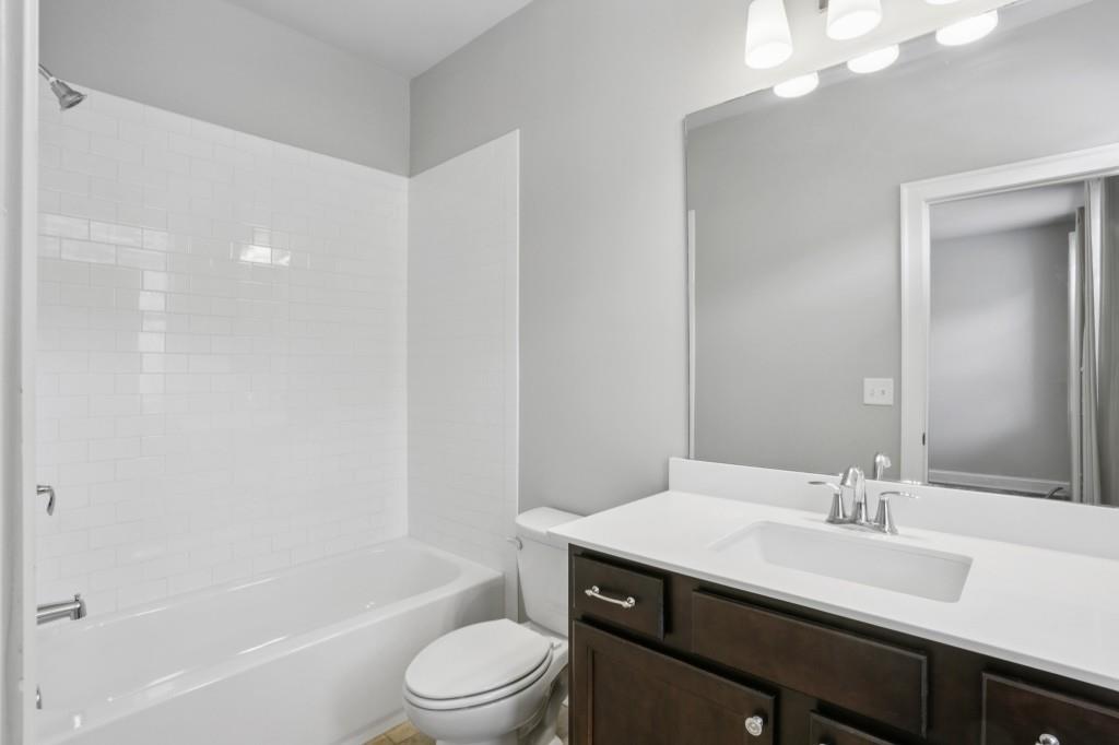 3899 Glenview Club Lane Duluth, GA 30097 - Photo 28 of 38 a bathroom with a sink a toilet a mirror and shower