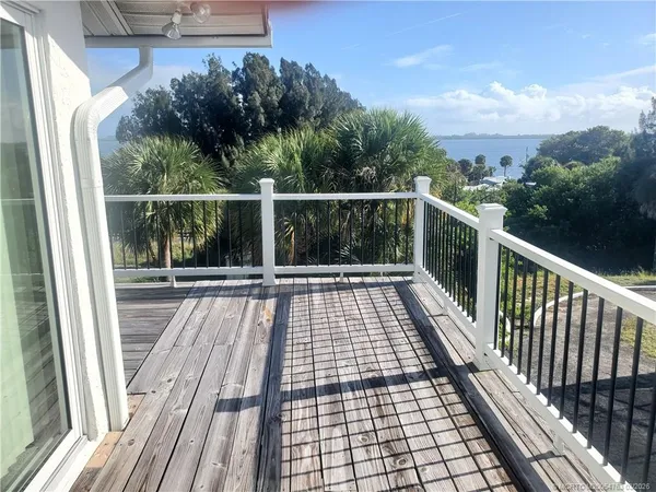 a view of balcony with wooden floor and fence