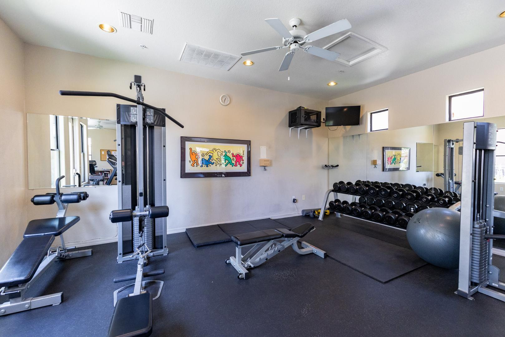 7027 North Scottsdale Road, Unit 225 Scottsdale, AZ 85253 - Photo 37 of 48 a living room with gym equipment and a chandelier